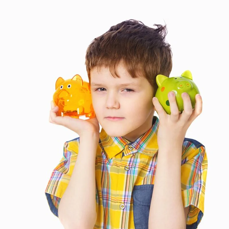 Dziecko trzyma prosiątko banka na lekkim tle